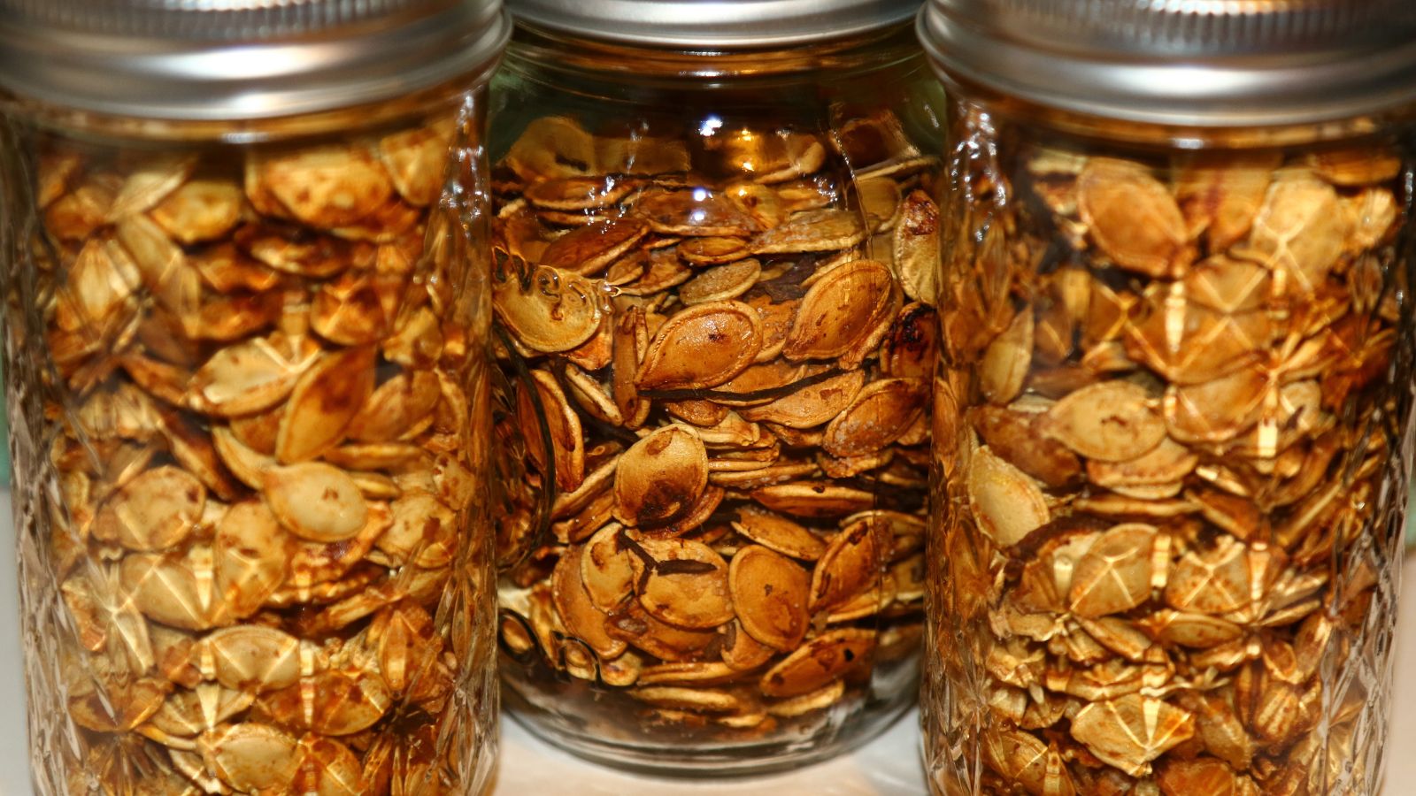 A close up shot of three jars with a the dried germ of an organic vegetable crop that is placed indoors.